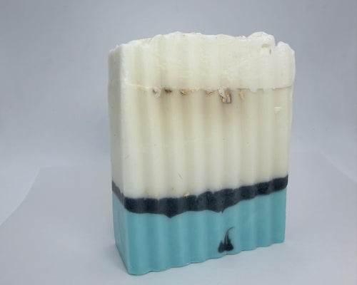 Artisan botanical soap bar with ridged texture on stone surface